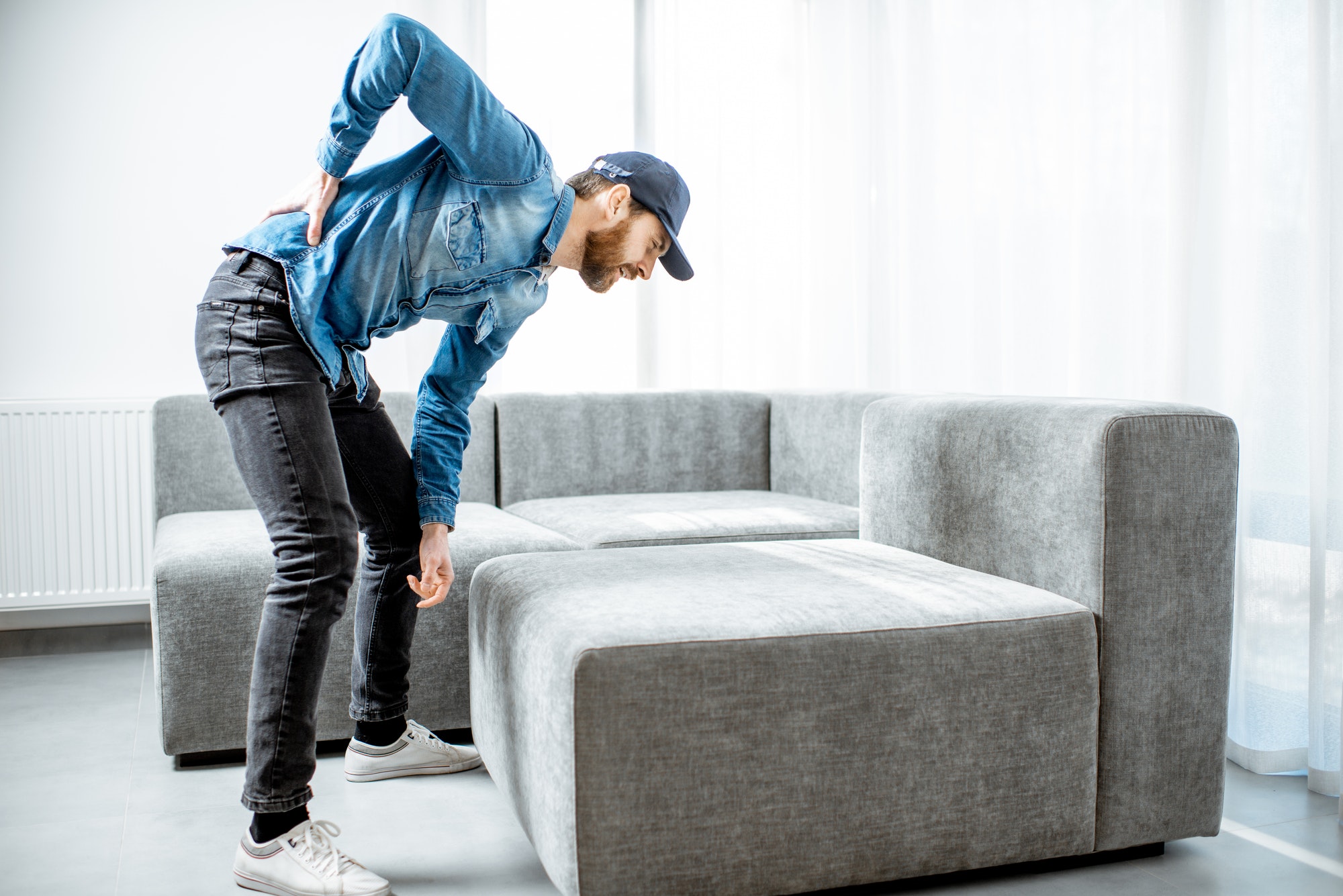 Man moving couch with back ache